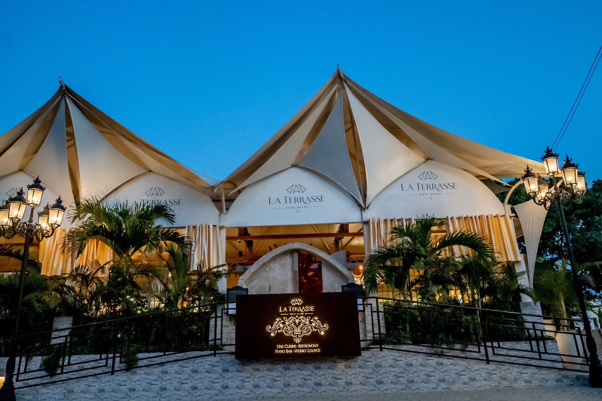 Exterior entrance of La Terrasse Diani Beach at dusk